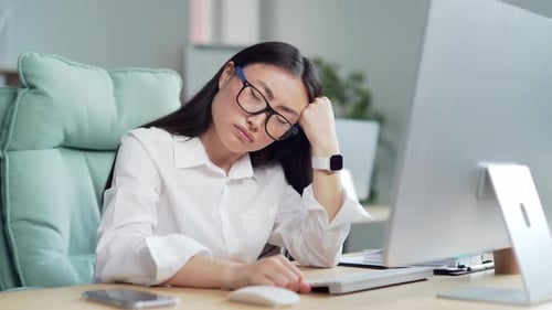 exhausted from stress overworked young asian woman worker in office at computer desk suffering