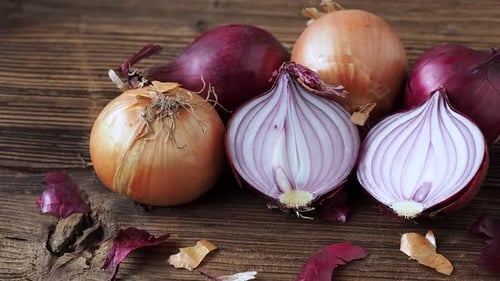 Yellow and red onions on a wooden board