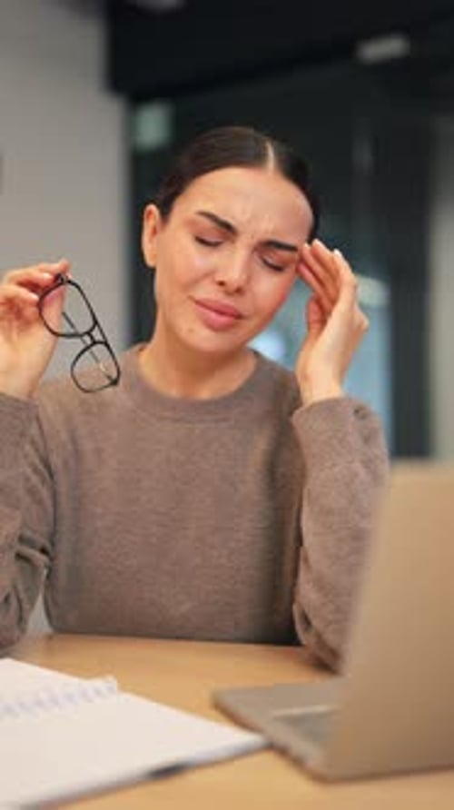 Woman Rubbing Temples at Desk with Laptop