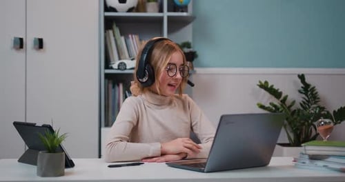 Blonde Child Communicating Online with Laptop and Headset