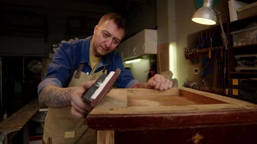 Man Inspecting Furniture in his Workshop