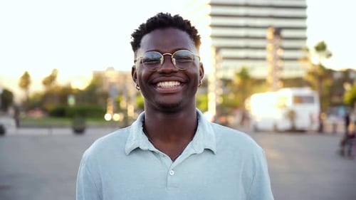 African Man Standing Outdoors Looking at Camera Happily During the Day at Beach City
