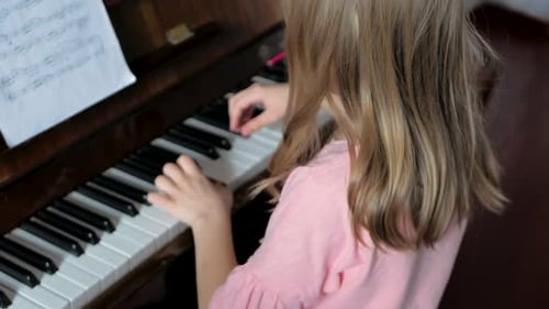 Child Plays Piano at Home, Reads Sheet Music