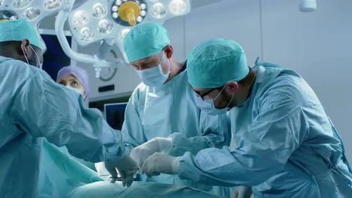 Im Operationssaal des Krankenhauses vernäht ein buntes Team von professionellen Chirurgen und Krankenschwestern die Wunde danach