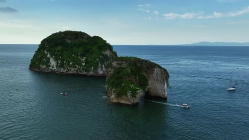 Aerial view of a boat driving through the a Mismalyoa arches in Puerto Vallarta, Mexico