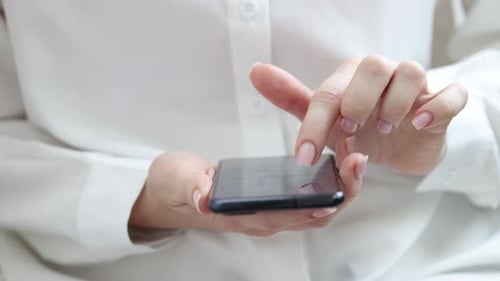 Hands Scrolling on Black Smartphone