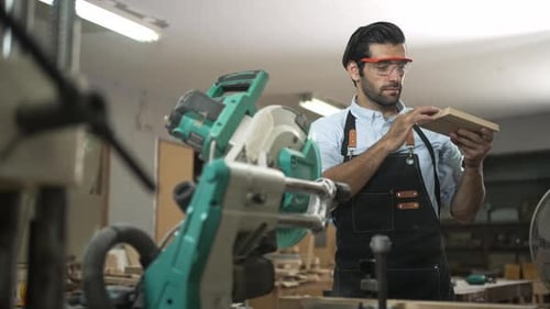 Carpenter is working together at workshop.