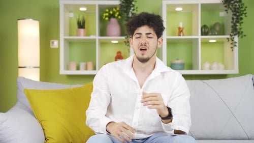Young man sneezing.