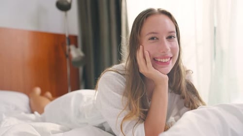 Smiling Woman Relaxing in Bed in White Shirt