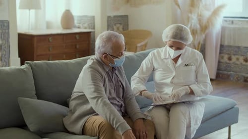 Doctor in Medical Wear Talking with Old Man Before Vaccination