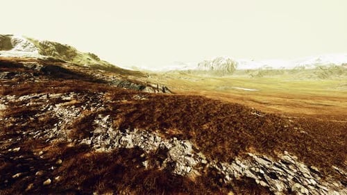 A Picturesque Mountain Landscape with a Lush Green Field in the Foreground