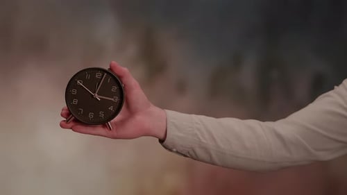 Arm Holds Clock, Time Passes