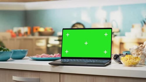Green Screen on Laptop in Modern Home Kitchen with Cupboards and Cookware
