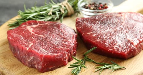 Fresh Raw Steaks with Rosemary on Cutting Board