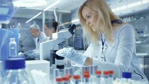 Scientist Using Microscope in Modern Medical Research Laboratory