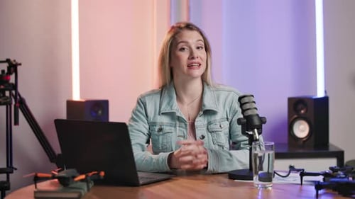 Interview, laptop and microphone with host woman in recording studio for broadcast or live stream