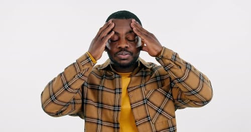 Man, headache and pain in studio for stress, vertigo and brain fog on white background