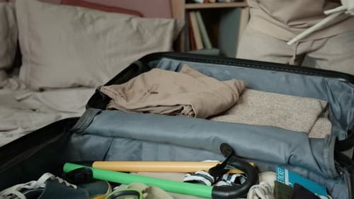 Mains d'une femme noire anonyme emballant une valise et la fixant avec une sangle