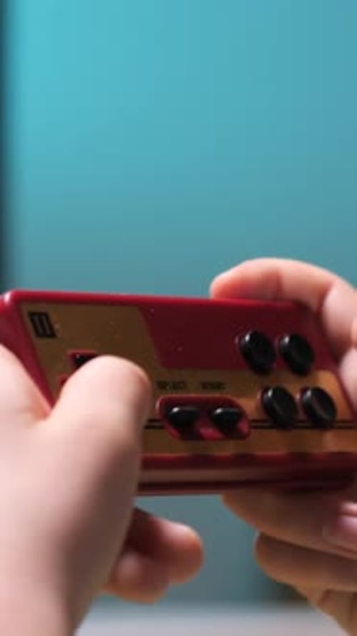 Child Plays a Retro Handheld Gaming Device