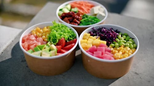 Close view of three poke bowls with vegetables, fruits, fish and seaweed salad