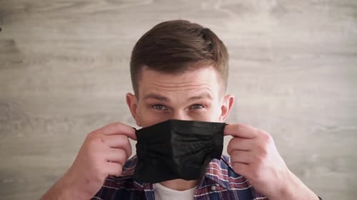 Young Adult Puts on a Face Mask