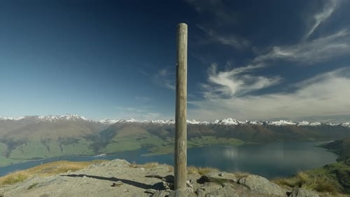 Wooden Summit Pole on Isthmus Peak in New Zealand with amazing view of landscape