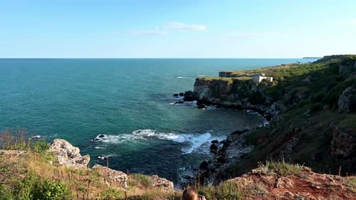 Girl enjoying the view of picturesque rocky coastline