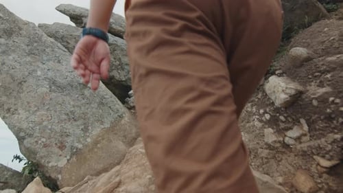 Couple Hiking Among the Sharp Rocks and Climb the Hill