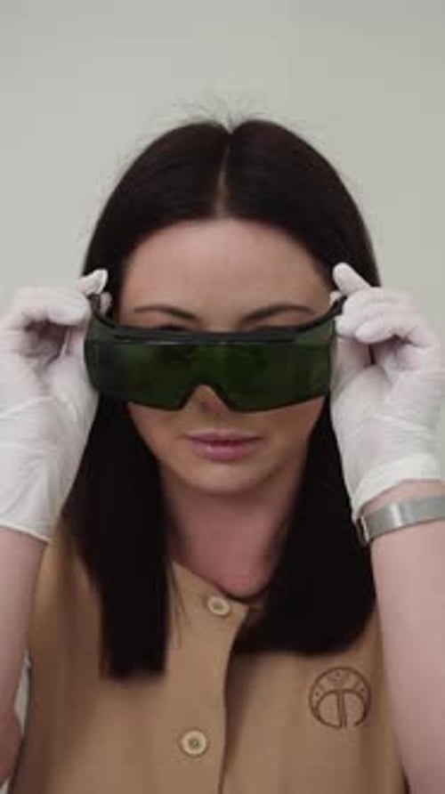 Woman Putting on Protective Eyewear