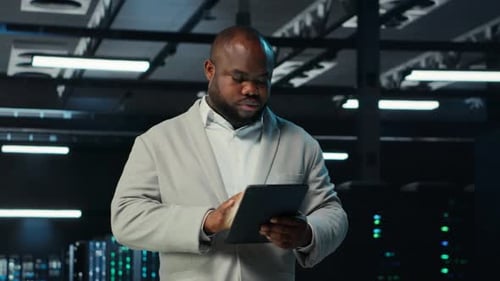 System Administrator Walking in Data Center Analyzing Infrastructure Performance