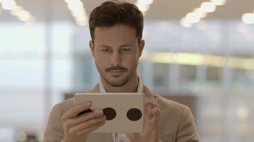 Portrait of Young Successful Man Using Tablet Screen on Business Travel Trip