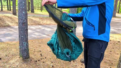 a person putting up a tent in a forest