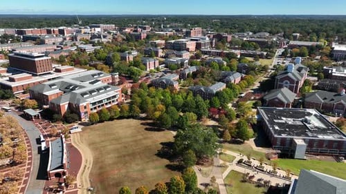 University campus with green space and brick buildings. Aerial footage of college grounds.