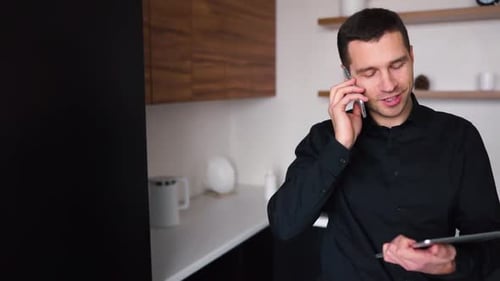 Young Adult Man Talking on Phone with Tablet