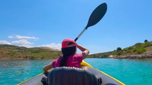 Woman Kayaking in Turquoise Water Near Green Island