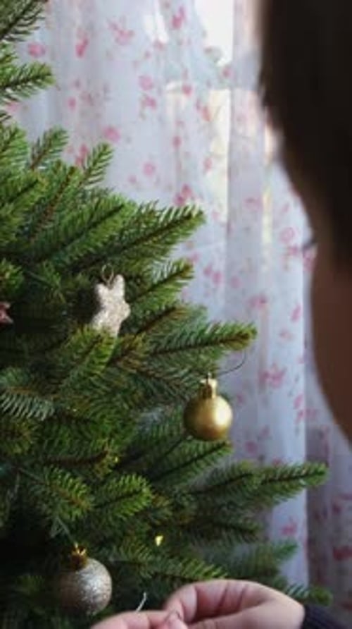 Child Decorating Christmas Tree with Ornaments