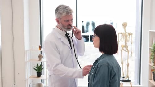 Doctor Examining Patient with Stethoscope in Office