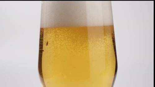 Close Up Glass Filling with Frothy Golden Beer