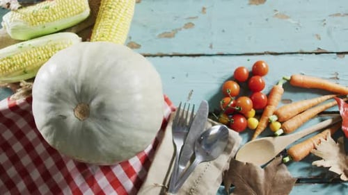 Close up view of pumpkin, multiple food ingredients and cutlery on wooden surface