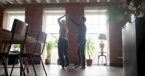 Couple Dancing Together Happily in Sunny Home