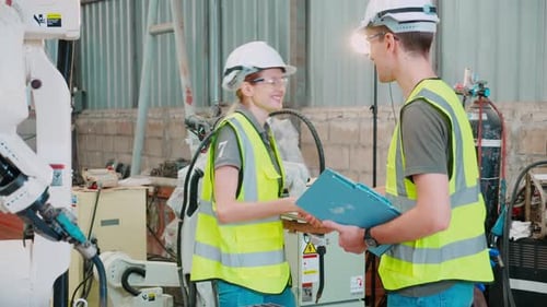Engineers Discuss Robotic Arm in Factory Setting