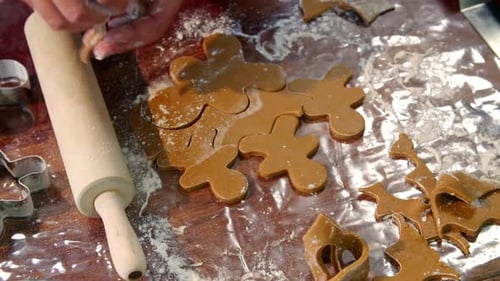 Person Making Holiday Cookies with Rolling Pin and Cutters
