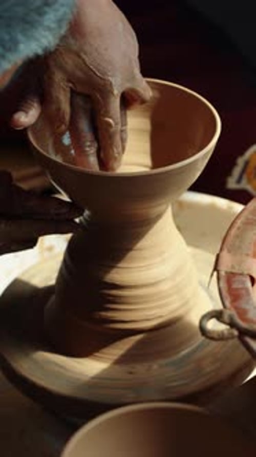 Vertical - Teacher and Student Shaping Pottery Together on Wheel, Close-Up of Hands and Clay