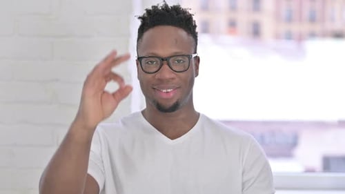 Young Adult Giving Ok Hand Gesture, Smiling