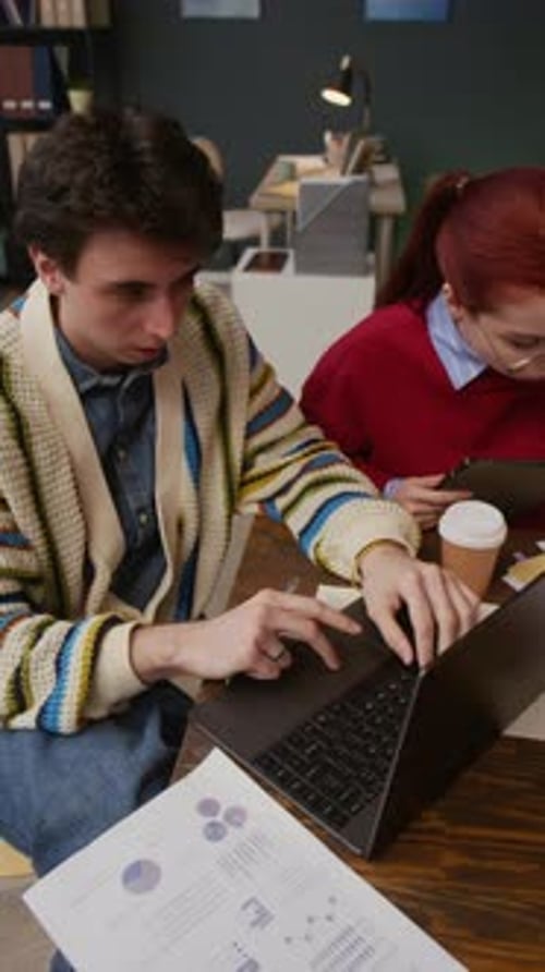 Coworkers Sitting at Office Table during Discussion of Business Papers