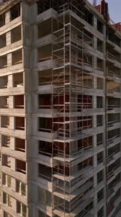 Vídeo de un Zumbido que captura el sitio de construcción de un edificio de gran altura al atardecer La estructura