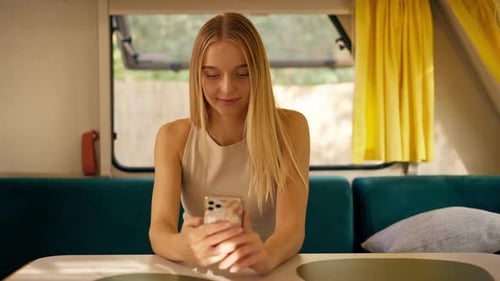 Blonde Woman Using Phone Inside RV Camper