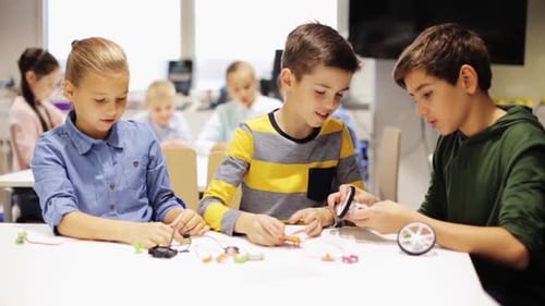 Children building robots together in school classroom