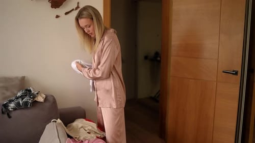 Young Adult Sorting Through Clothes Indoors