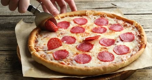 Delicious Pepperoni Pizza Being Cut with Pizza Cutter
